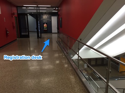 Turn left or right and head around the escalators to registration desk